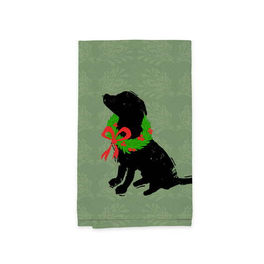 The Festive Lab Wreath Kitchen Tea Towel by Rustic County features a green design with a silhouette of a sitting dog embellished with a festive lab wreath and a red bow. The background includes an elegant floral pattern, making it an excellent addition to your holiday-themed kitchen decor.