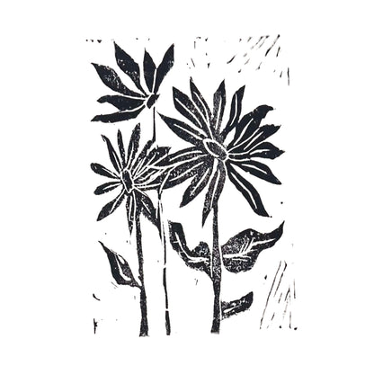 This Sunflowers Handmade Stamp Art by Rustic County showcases three stylized sunflowers with elongated petals and broad leaves in a striking black and white linocut print. The flowers' long stems stand out against a plain background, making it a perfect personal treasure for any admirer.